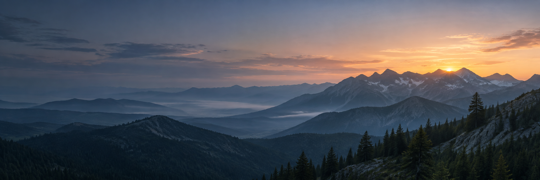 Layered mountain ridgelines beneath a soft sunrise